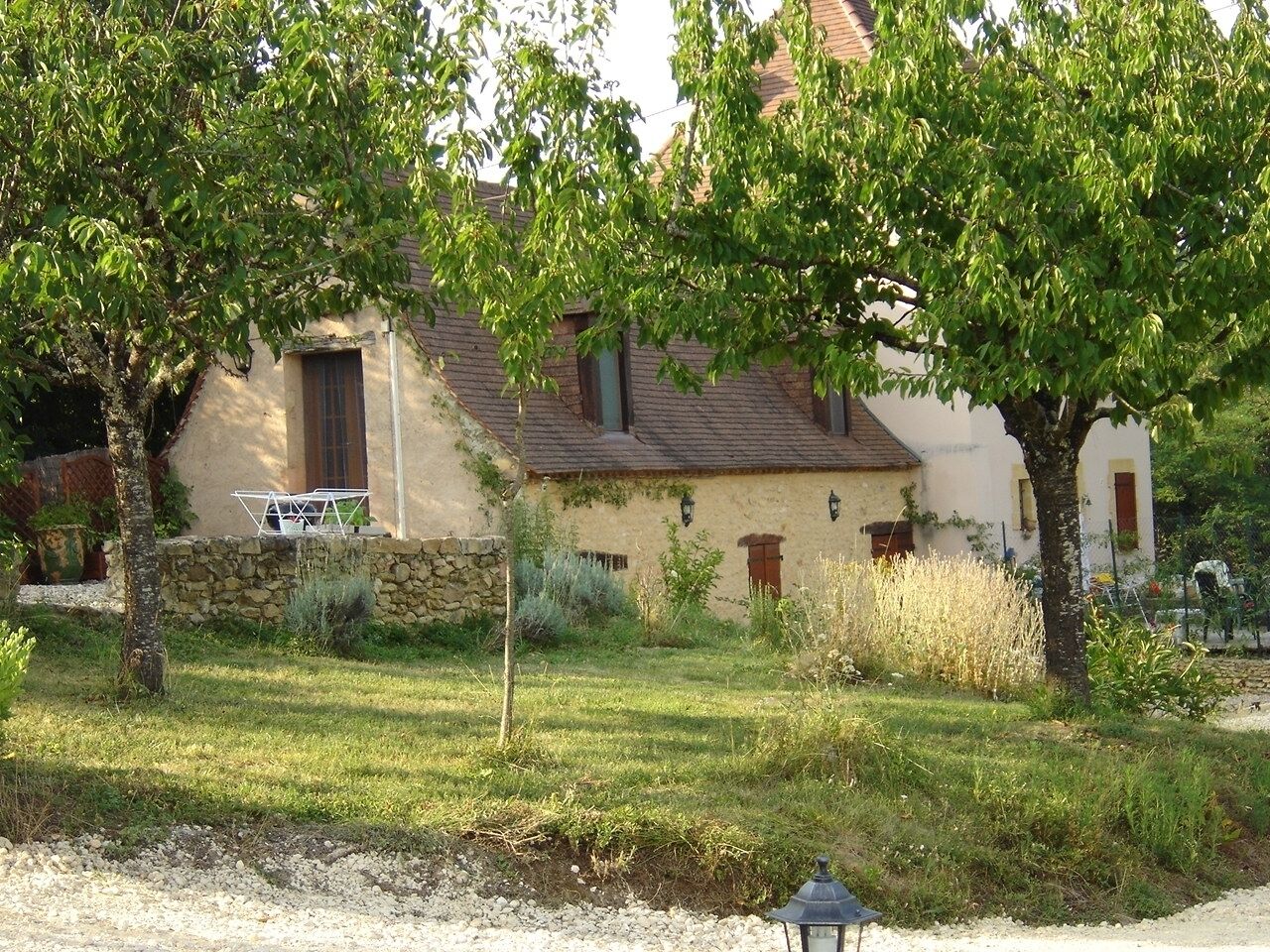 Una casa rústica con pared de piedra, puerta de madera y una ventana.
