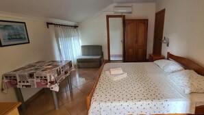 A bedroom with a bed, a table with a tablecloth, a chair, a wardrobe, and a picture on the wall. - Studio apartment in Orebić with Seaview, Terrace, Air condition, WIFI (4669-3) (Orebic)