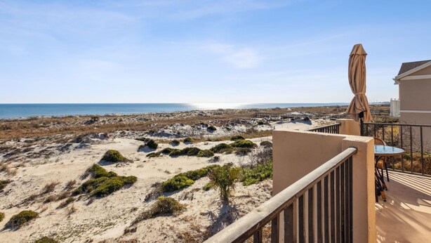 A balcony with a view of a beach and ocean.