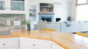 Een moderne keuken met witte kastjes, een houten aanrecht en een ingebouwde kookplaat.