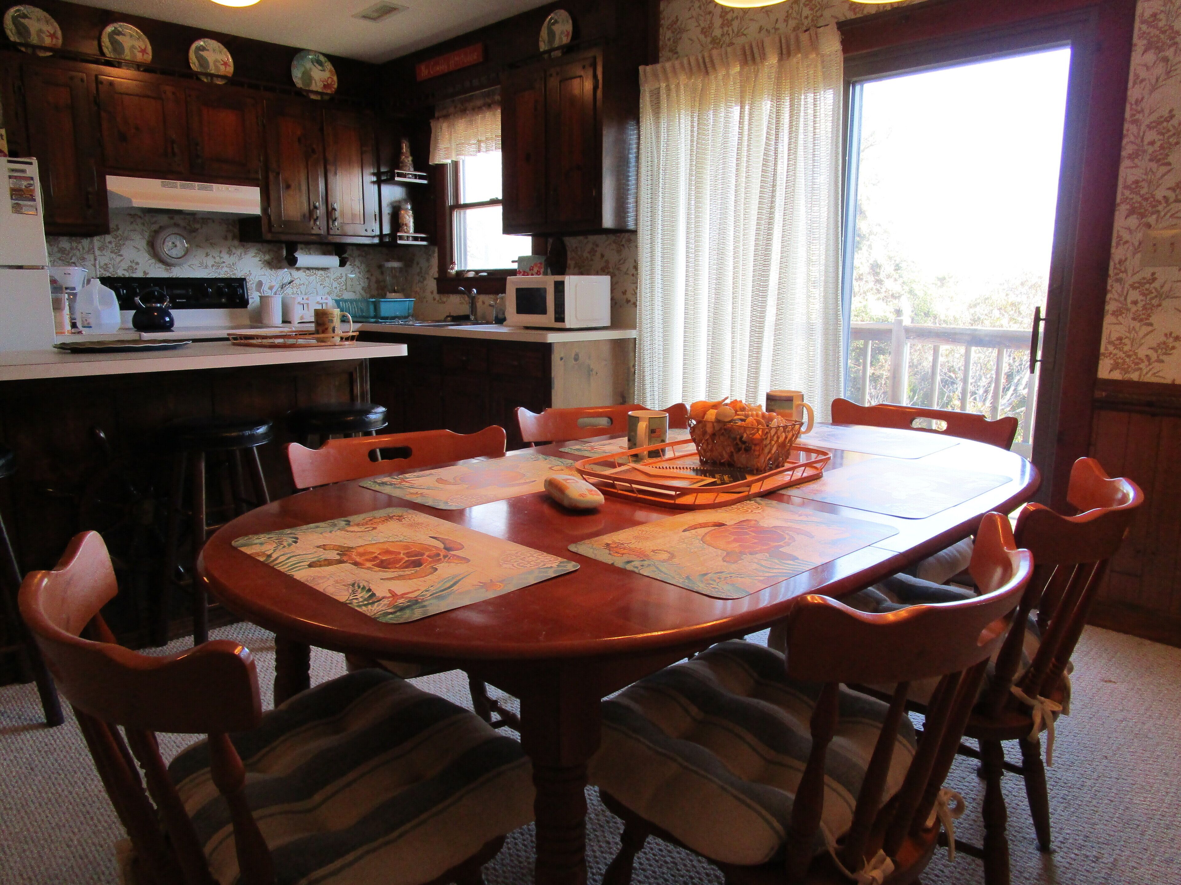A dining area with a wooden table, chairs, and a basket of bread.