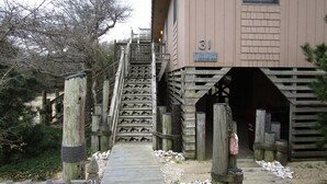 A wooden staircase leading to a building with a sign reading "Dolphin Run" and the number 31. - CAPTAINS QUARTERS - AN ALL INCLUSIVE VACATION RENTAL LOCATED IN SOUTHERN SHORES! (Kitty Hawk)