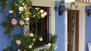 Un bâtiment à la façade bleue, doté d’un toit recouvert de tuiles et d’une porte avec une fenêtre.