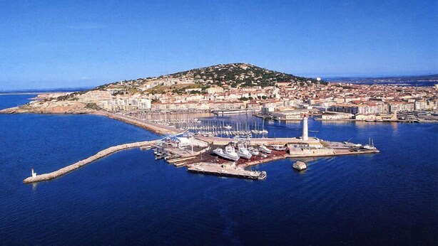 An aerial view of a coastal town with a marina, a lighthouse, and a hill with buildings. - CHARMING GUEST GARDEN TERRACE SWIMMING POOL, FREE PARKING AND WIFI, BEACHES 8 Km away  (Pomérols)