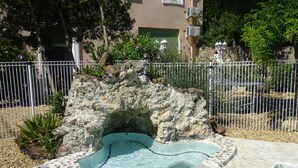 A swimming pool with a rocky edge, surrounded by a fence and various plants. - CHARMING GUEST GARDEN TERRACE SWIMMING POOL, FREE PARKING AND WIFI, BEACHES 8 Km away  (Pomérols)
