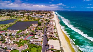Une zone résidentielle côtière comprenant des maisons, une plage et une étendue d’eau.