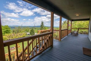 A wooden deck with a view of a mountainous landscape. - Dog-Friendly 2BR Home with Porch Swing, Fireplace & Foosball near Blue Ridge Parkway (Boone)