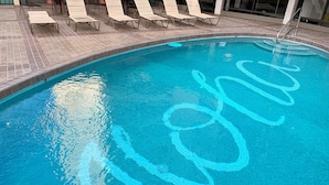 A swimming pool with a tiled edge and a blue pattern on the water surface. - 2-Bedroom Vacation Rental in Waikiki (Honolulu)