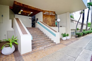Una scala conduce a un edificio con un cartello che riporta la scritta “ROYAL ALOHA 1909 ALA WAI BLVD.”
