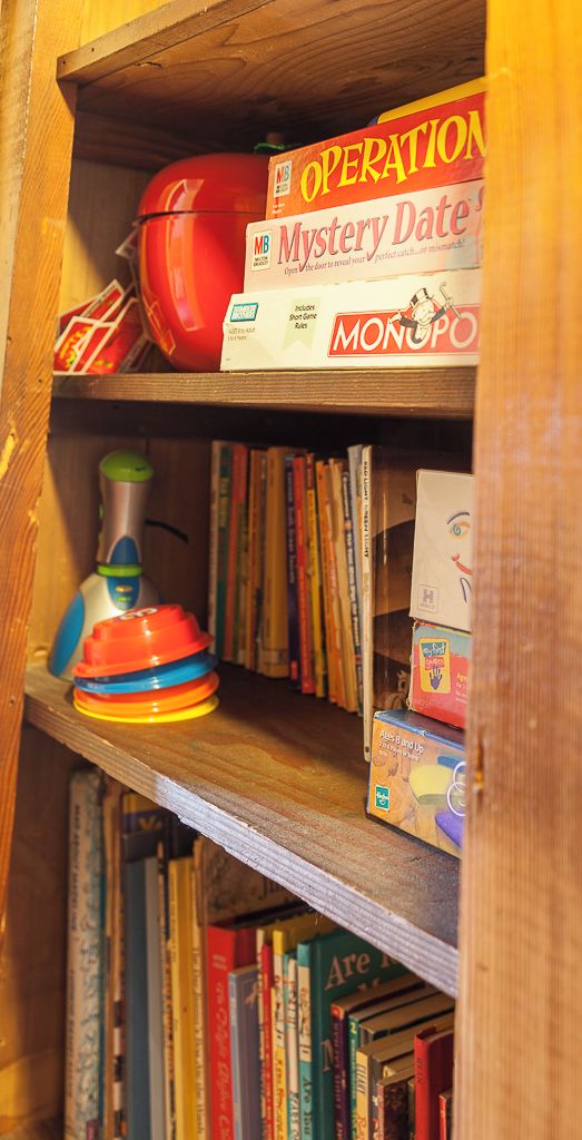 A bookshelf with various board games and books.