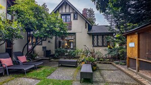 A courtyard with a house, outdoor seating, and a sign for fresh eggs. - Seattle Carriage House: Private Urban Retreat with Chickens (Seattle)