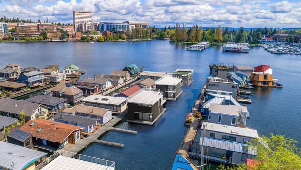 A marina with boats docked, surrounded by residential buildings and a city skyline in the background. - Seattle Carriage House: Private Urban Retreat with Chickens (Seattle)