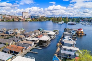 A marina with boats docked, surrounded by residential buildings and a city skyline in the background. - Seattle Carriage House: Private Urban Retreat with Chickens (Seattle)