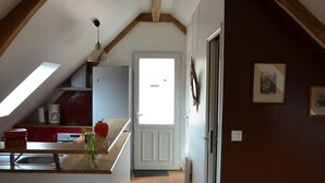 A kitchen with wooden beams, a red appliance, and a window. - Gite d'OrAppart. for rent 1,400  (Vouvray)