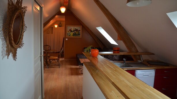 A kitchen with a wooden countertop, a sink, and a dishwasher. There is a dining area with a table and chairs. - Gite d'OrAppart. for rent 1,400  (Vouvray)