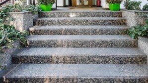A set of stone steps leading to a door under a covered area with a skylight. - Richter Pansion (Budapest)