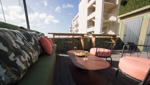 Un espacio al aire libre con una mesa redonda, sillas y un sofá.
