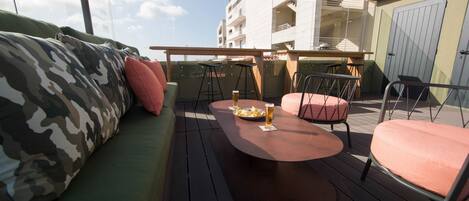 An outdoor seating area with a round table, chairs, and a sofa.