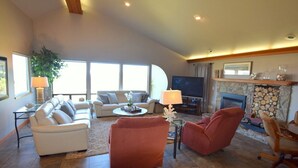 Amplia sala de estar con chimenea, televisor y asientos cómodos.