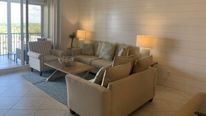 A modern living room with a sofa, armchairs, and a coffee table. There are two lamps and a ceiling fan. - Enjoy Gorgeous Panoramic Views Of The Gulf Of Mexico And Vanderbilt Bay  (Naples)
