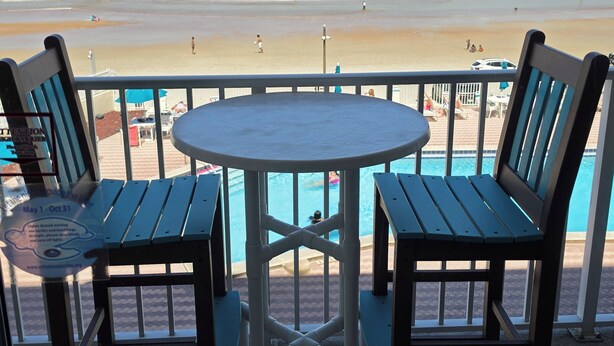 A beachside seating area with a view of the ocean. - Brandy's Direct Ocean View Over The Large Heated Pool & Hot Tub, Sleeps 4 (Daytona Beach)