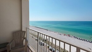 A balcony with a view of a beach and ocean.