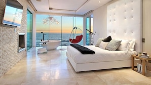 Une chambre à coucher moderne avec un grand lit, un fauteuil suspendu, une baignoire et une vue sur la mer.