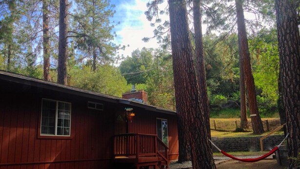 A rustic cabin with a wooden exterior, a porch, and a hammock. - Anglers Rest (Oakhurst)