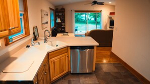 Una cocina moderna con lavavajillas, pileta doble y armarios de madera.