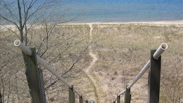 Walk along the beachside boardwalk, flanked by wooden posts and metal railings, to the ocean's edge.