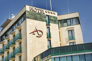 A hotel building with a prominent 'HOTEL' sign, multiple balconies, and a modern architectural design. - Alexandra Business Hotel (Puchov)