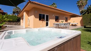 A house with a hot tub in the backyard, a patio with outdoor furniture, and a stone wall. - Finca La Gaviota - Los Limoneros (Icod de los Vinos)