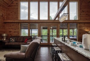 Relax in this inviting space with a comfortable sofa, matching bench, and a small table with a bar counter.