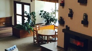 Un vaste espace de vie doté d’une cheminée, d’une table à manger et de sièges confortables.