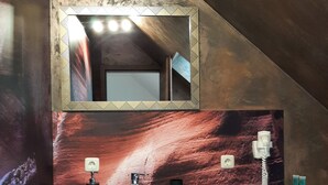 Un bagno con un lavandino bianco, uno specchio e un telefono.