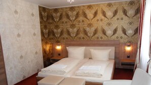 Una camera d'albergo con un letto grande, due comodini, una sedia e un tappeto rosso.
