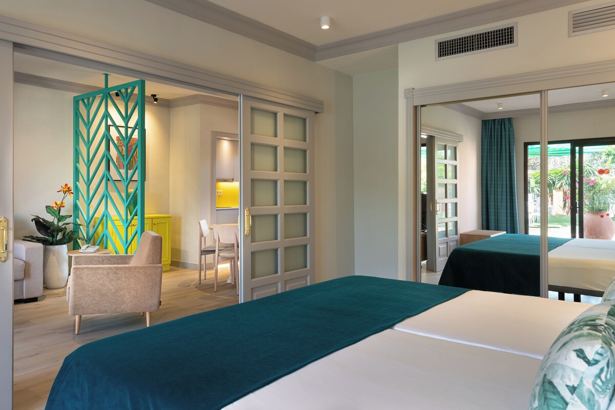 A hotel room with a bed, a chair, a desk, and a view of the outdoors.