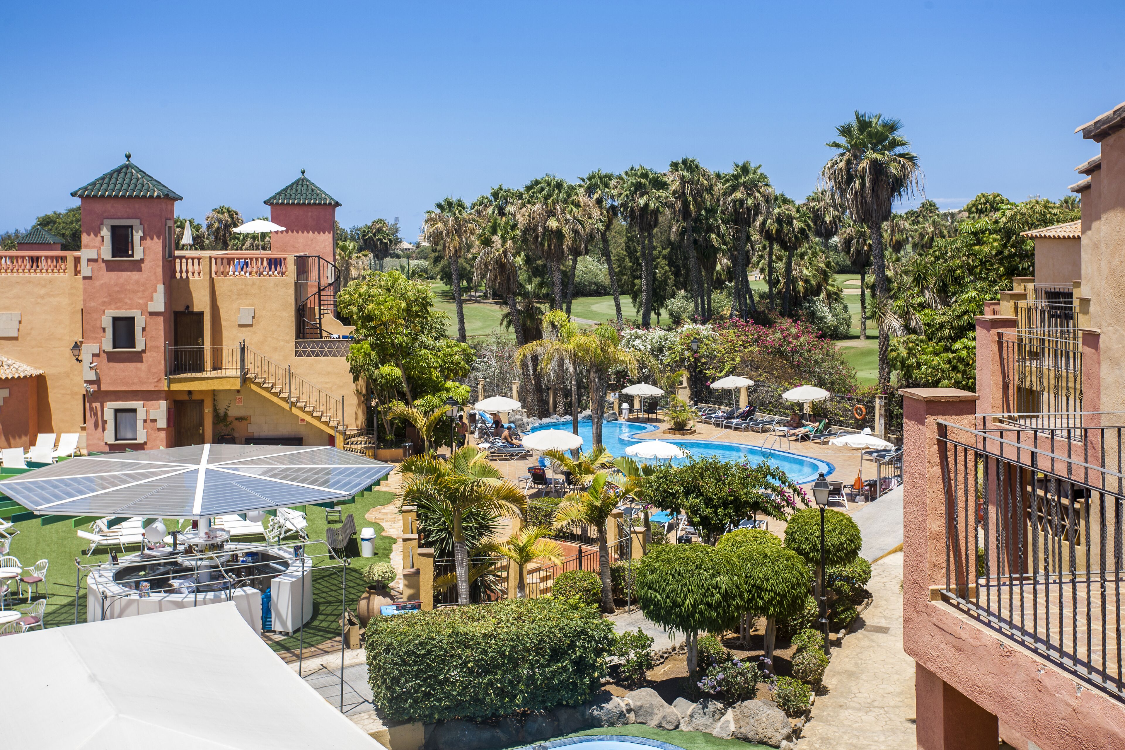 Un resort con piscina, tumbonas y bañera de hidromasaje.