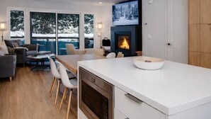 A modern kitchen with a built-in oven, a white countertop, and a fireplace. - Scandinavian 72 Vantage Condo with Private Hot Tub by RedAwning (Park City)