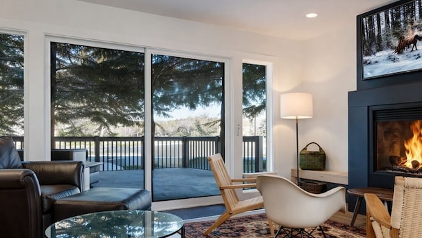 A modern living room with a glass coffee table, leather sofa, and a fireplace. - Scandinavian 72 Vantage Condo with Private Hot Tub by RedAwning (Park City)