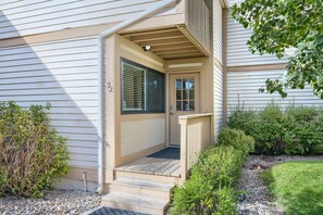 Une maison avec un porche à l’avant, une porte avec une fenêtre et une boîte aux lettres.