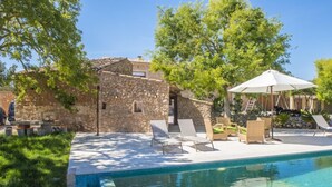 A stone building with a pool, outdoor seating, and a shaded area with an umbrella. - Typical country property with Yacuzzi pool and large outdoor area (Porreres)