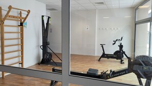 A gym with a treadmill, a rowing machine, and a pull-up bar. - La Mongie 2 rooms 4 persons Residence Pic du Midi parking and swimming pool (Bagnères-De-Bigorre)