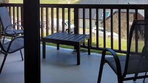 A balcony with a view of mountains, a stone wall, and a parked car. - La Mongie 2 rooms 4 persons Residence Pic du Midi parking and swimming pool (Bagnères-De-Bigorre)