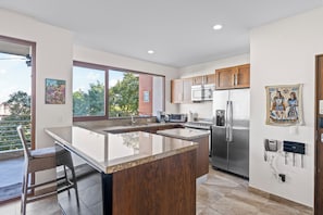 A modern kitchen with a large island, stainless steel appliances, and wooden cabinets. - Residences by Pinnacle, Rooftop Pool & Bar, Zona Romantica, Puerto Vallarta (Puerto Vallarta)