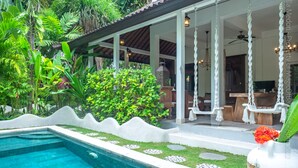 A poolside area with a clear view of the pool, a covered seating area with hanging chairs, and lush greenery surrounding the space. - Bright and Quiet Villa for 6 people. Close to Shops in Seminyak (Seminyak)