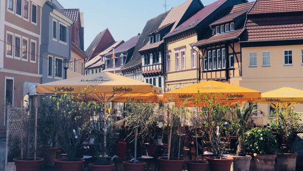 Una hilera de edificios europeos tradicionales con carpas de cerveza Schöfferhof al frente.