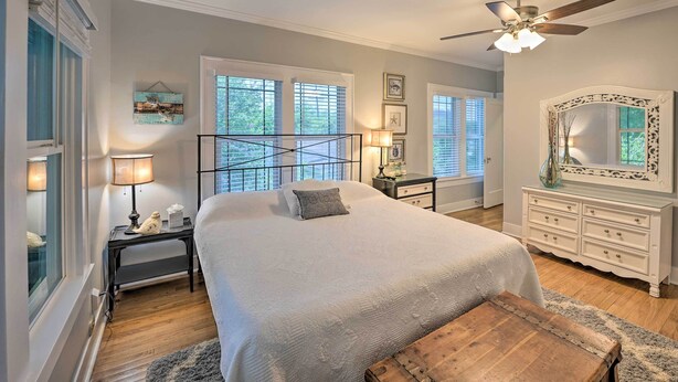A bedroom with a large bed, a ceiling fan, a dresser, and a nightstand with a lamp. - Corpus Christi Home w/ Pool & Hot Tub: Walk to Bay (Corpus Christi)