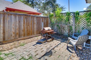 A backyard with a wooden fence, a barbecue grill, and a patio area with chairs. - Corpus Christi Home w/ Pool & Hot Tub: Walk to Bay (Corpus Christi)