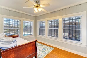 A bedroom with a bed, a wooden headboard, a ceiling fan, and large windows with blinds. - Corpus Christi Home w/ Pool & Hot Tub: Walk to Bay (Corpus Christi)